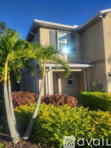 A house with a palm tree in front of it.