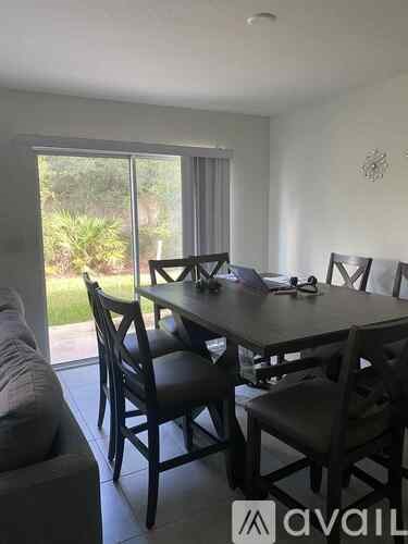 A dining room with a table and chairs.