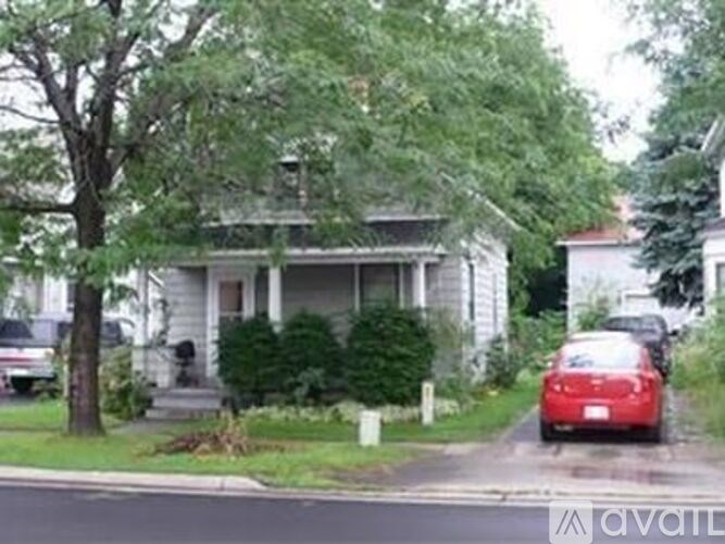 A red car is parked on the side of a street.