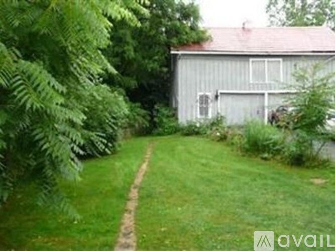 A house with a garage is surrounded by greenery.