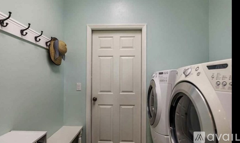 A laundry room with a washer and dryer and a door.