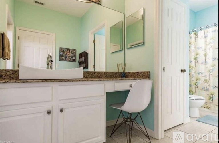 A bathroom with a white chair and a counter.