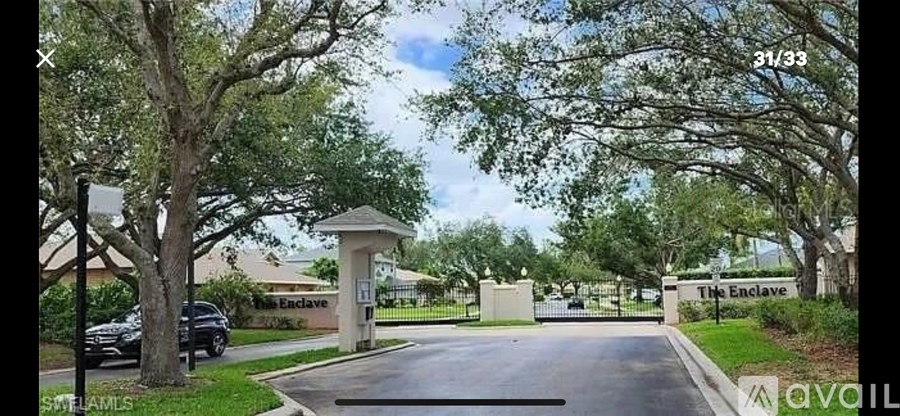 A gated entrance to a residential area with a sign that reads "The Enclave.".