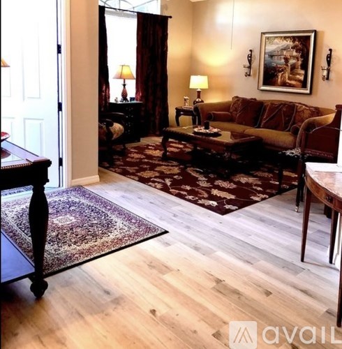 A living room with a brown couch, a coffee table, and a rug.