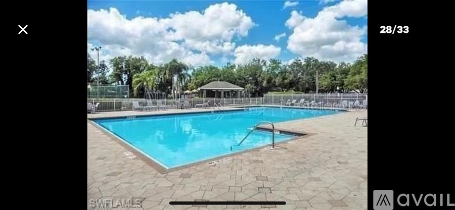 A swimming pool surrounded by a fence and trees.