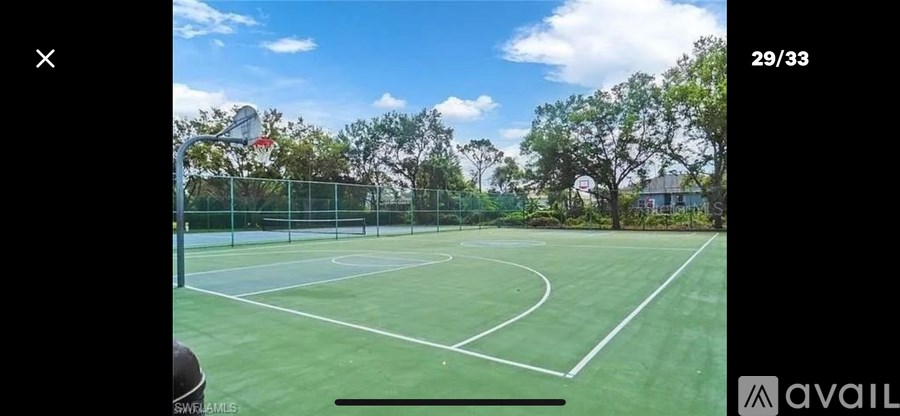 A tennis court with a net and trees in the background.