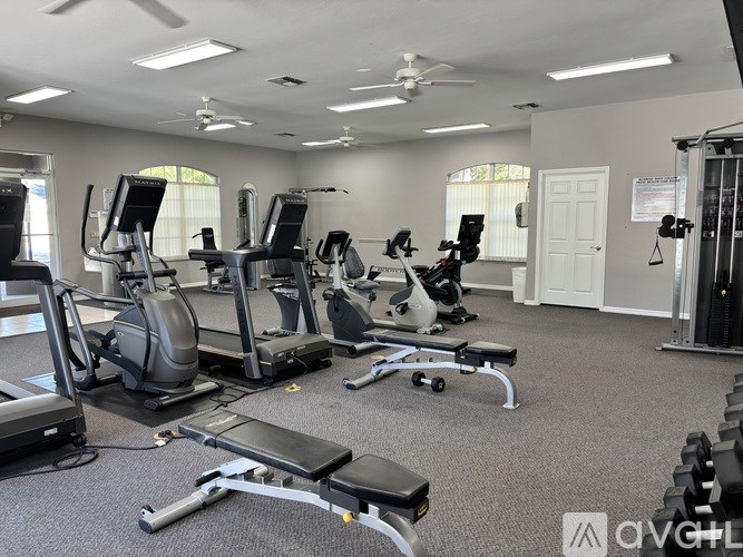 A well-equipped gym with treadmills, stationary bikes, and dumbbells.