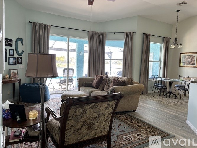 A living room with a couch, chairs, and a dining table.