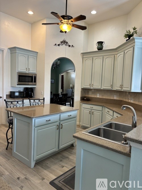 A kitchen with a fan and a sink.