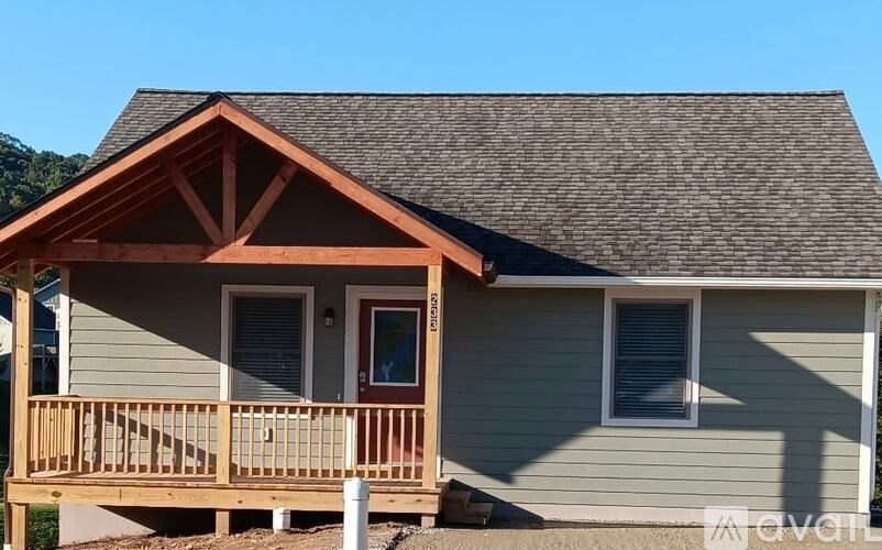 A house with a grey siding and a brown roof.