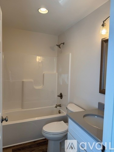 A white toilet sits next to a bathtub in a bathroom.