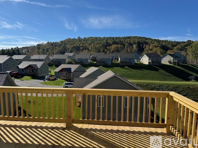 A wooden deck overlooks a residential area with houses and greenery.