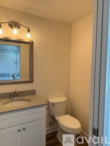 A small bathroom with a toilet, sink and mirror.