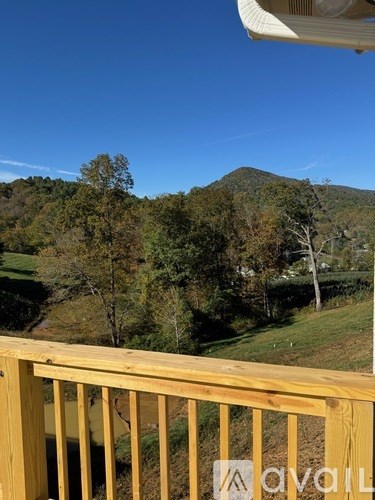 A wooden deck overlooks a lush green valley.
