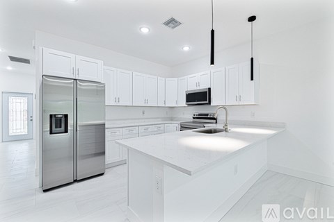 A modern kitchen with white cabinets and a central island.