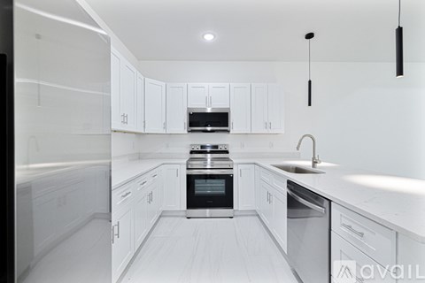 A modern kitchen with white cabinets and stainless steel appliances.