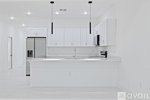 A modern kitchen with white cabinets and a white island.