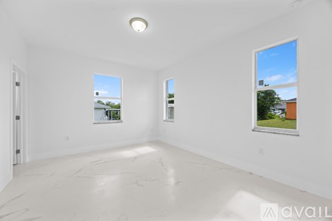 A large empty room with a view of the sky through the windows.