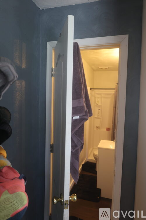 A bathroom with a towel hanging on the door.