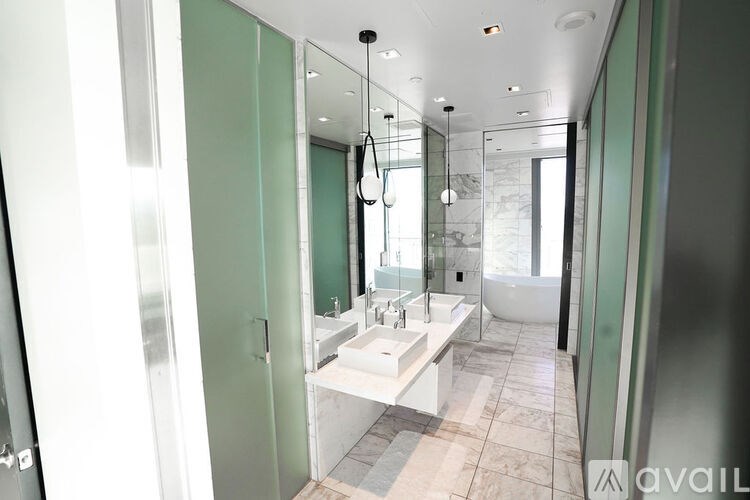 A bathroom with a white sink and a glass shower stall.