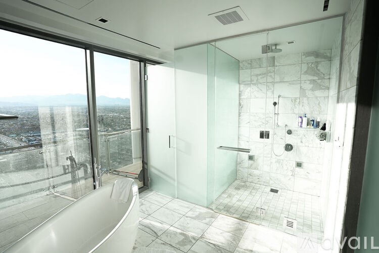 A modern bathroom with a large window overlooking a cityscape.