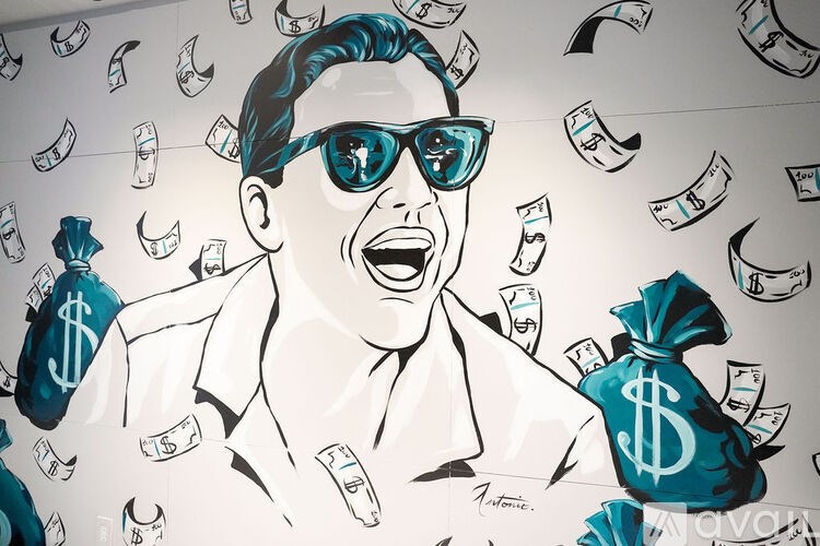 A man with sunglasses and a bag of money is surrounded by flying money.
