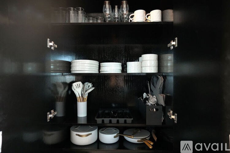 A kitchen shelf with various dishes and utensils neatly arranged.