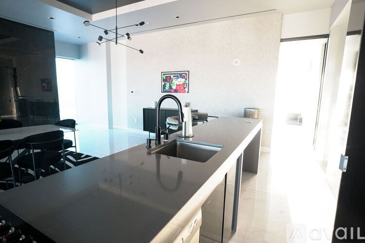 A modern kitchen with a large island and a dining table.