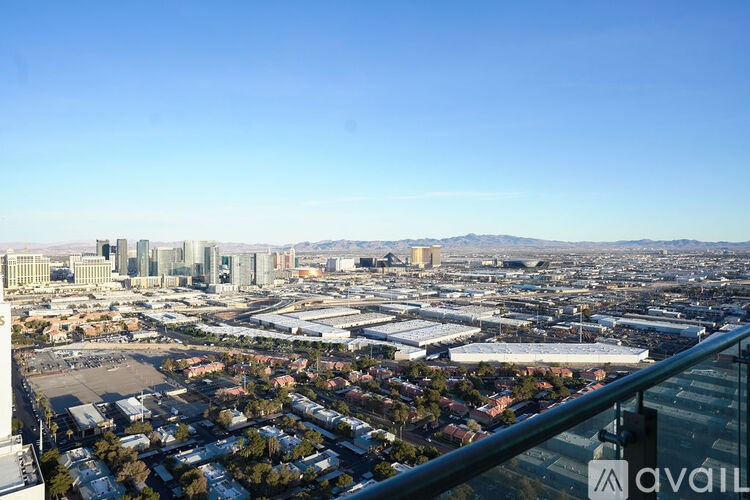 A cityscape with buildings and a mountain range in the distance.