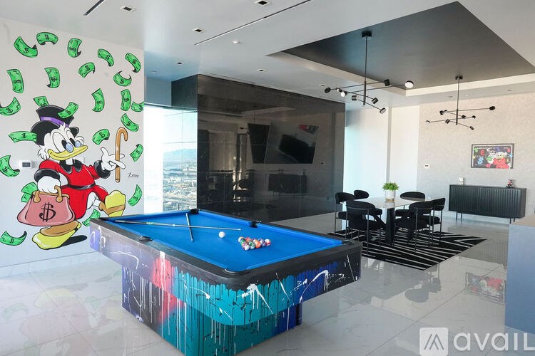 A pool table with a Donald Duck mural on the wall.