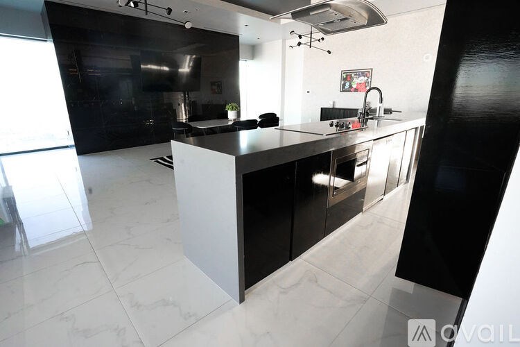 A modern kitchen with black and white appliances and a marble floor.