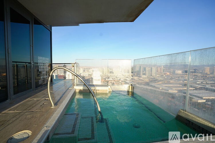 A pool on a balcony with a view of the city.