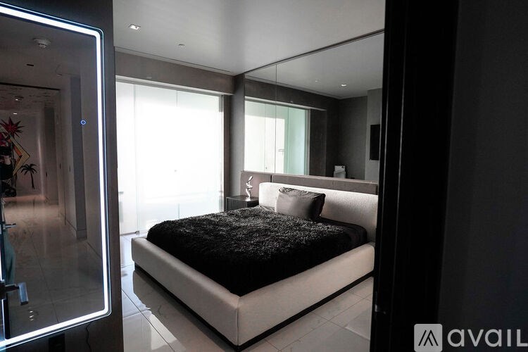 A bedroom with a large bed and a glass door.