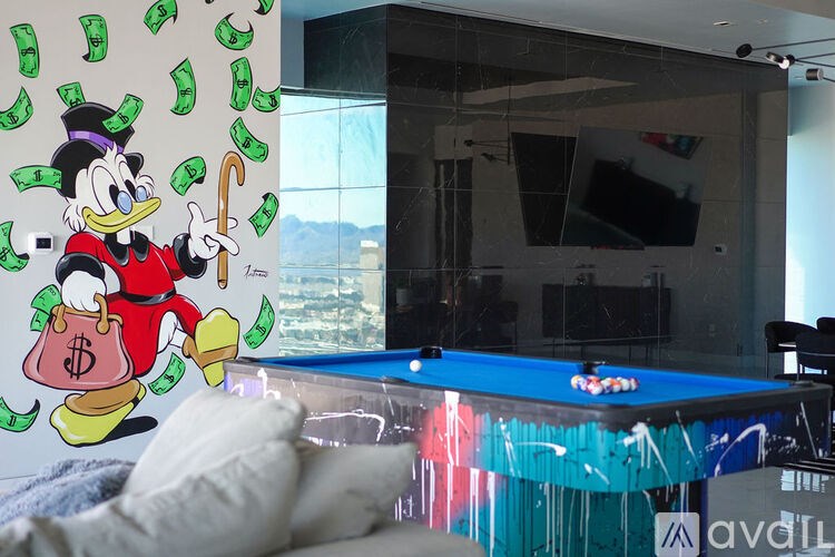A pool table with a Donald Duck mural on the wall.