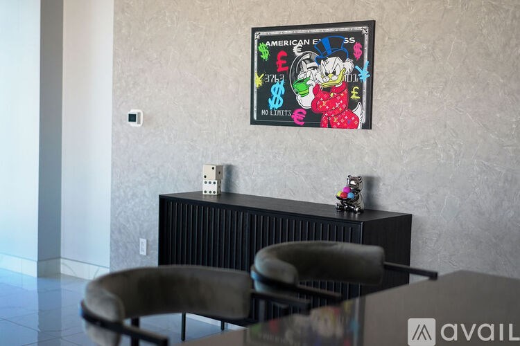 A framed poster with a cartoon character on it is hanging on a wall above a black radiator.