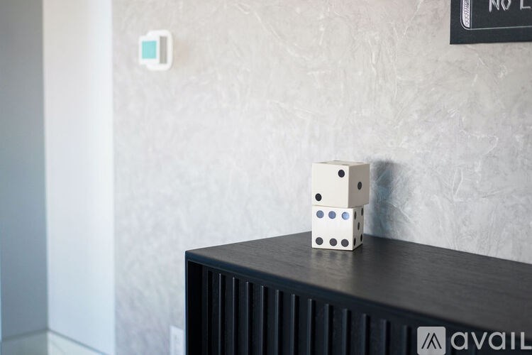 A white dice sits on top of a black box.