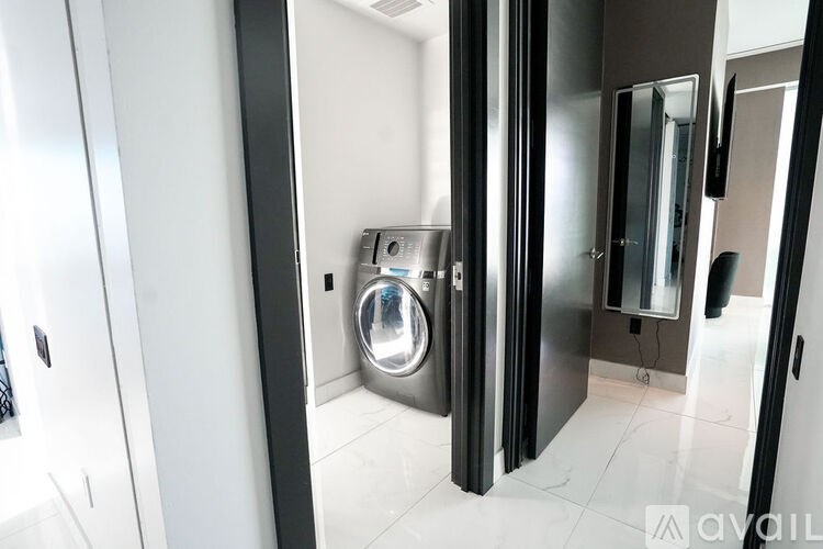 A modern bathroom with a shiny stainless steel washing machine.