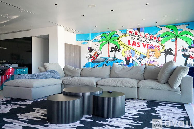 A living room with a large mural of the Las Vegas sign on the wall.