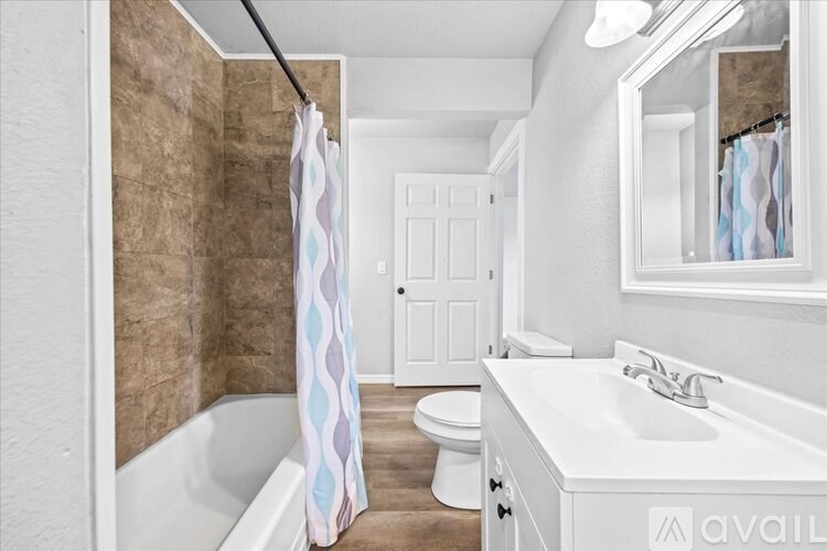 A bathroom with a white tub, sink, and toilet.
