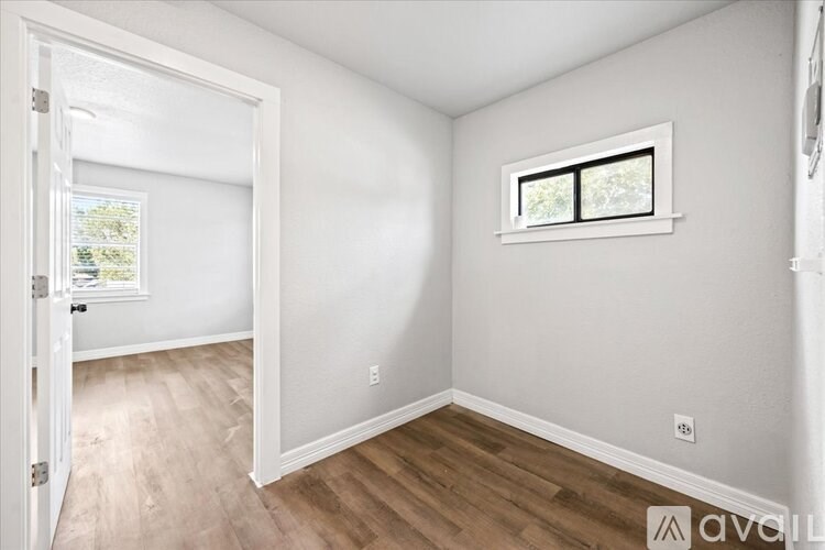 A room with a window and wooden flooring.