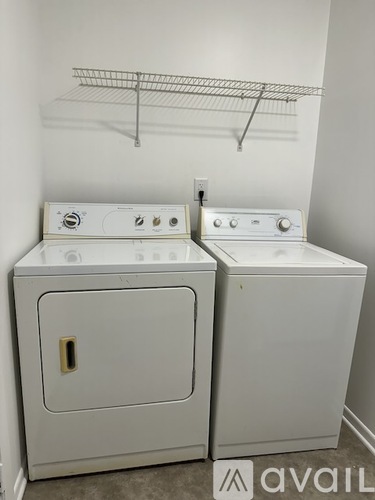 Two white front loading washing machines in a laundry room.
