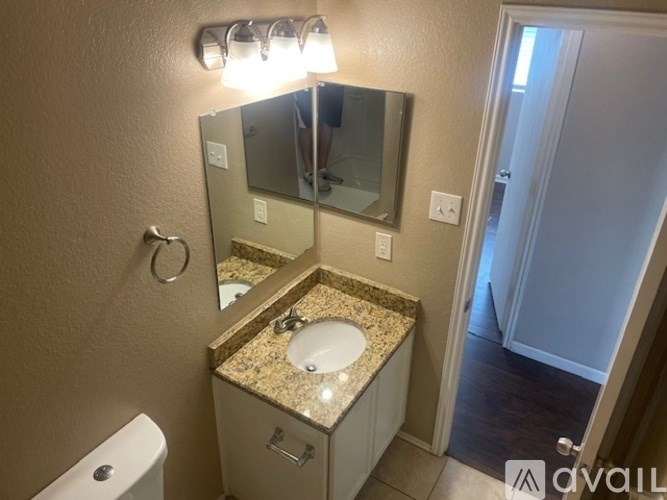 A bathroom with a sink, mirror, and toilet.