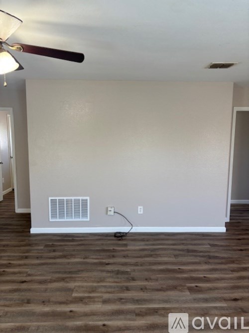 A room with a fan and a wall socket.