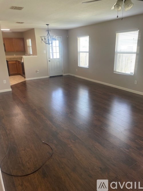 A room with wooden flooring and a chandelier.