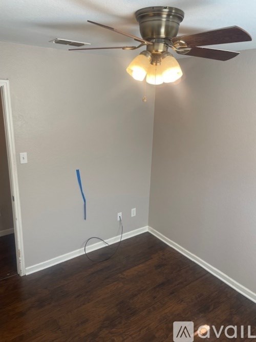 A room with a ceiling fan and a light on.