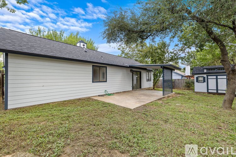 A house with a garage and a tree in front.