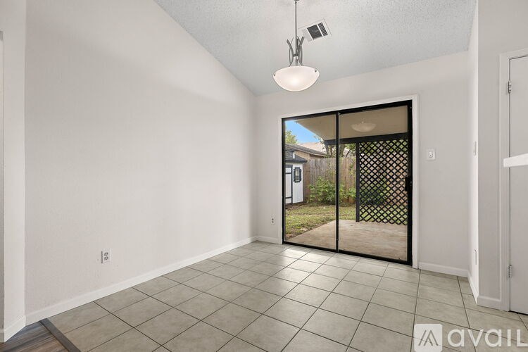 A room with a sliding glass door leading to a backyard.