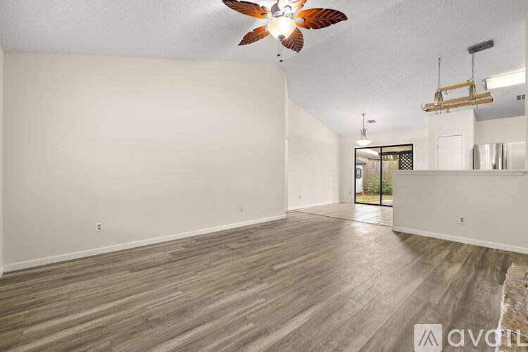 A room with wooden flooring and a ceiling fan.