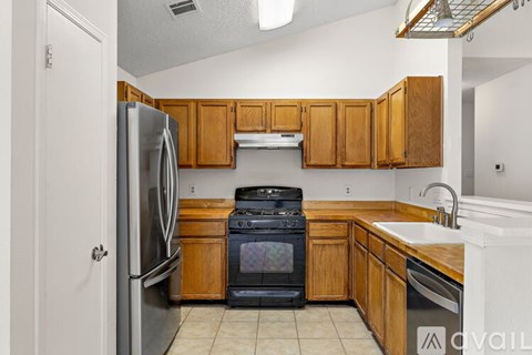 A kitchen with wooden cabinets and a black oven.