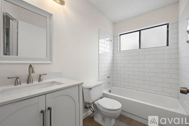 A white bathroom with a toilet, sink, and bathtub.